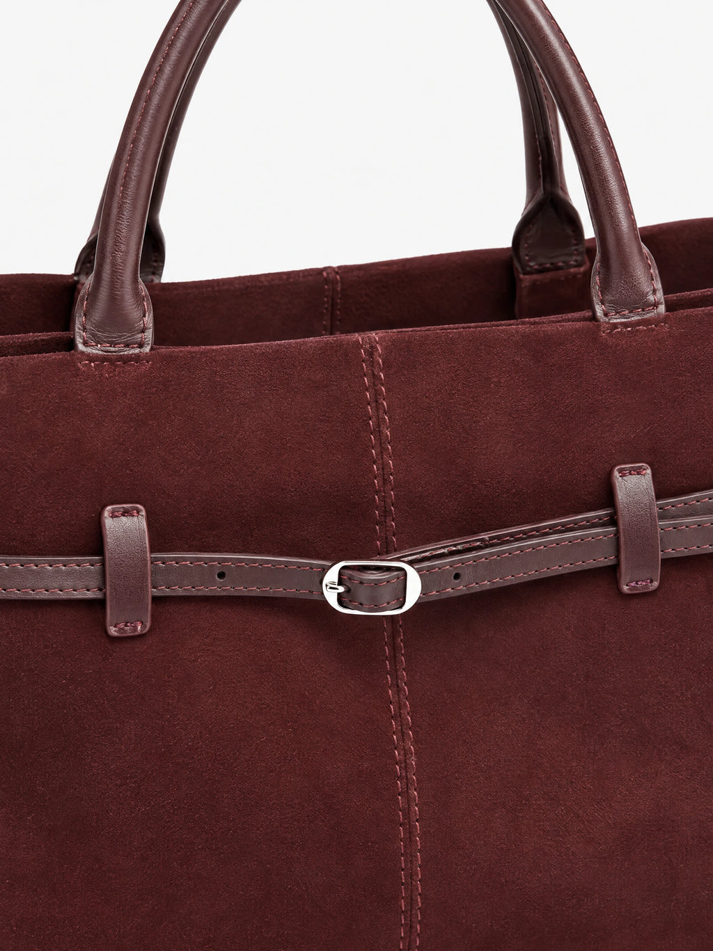 Close-up of the Wine Suede Leather Tote Bag showing stitched handles, suede texture, and an adjustable front buckle strap.