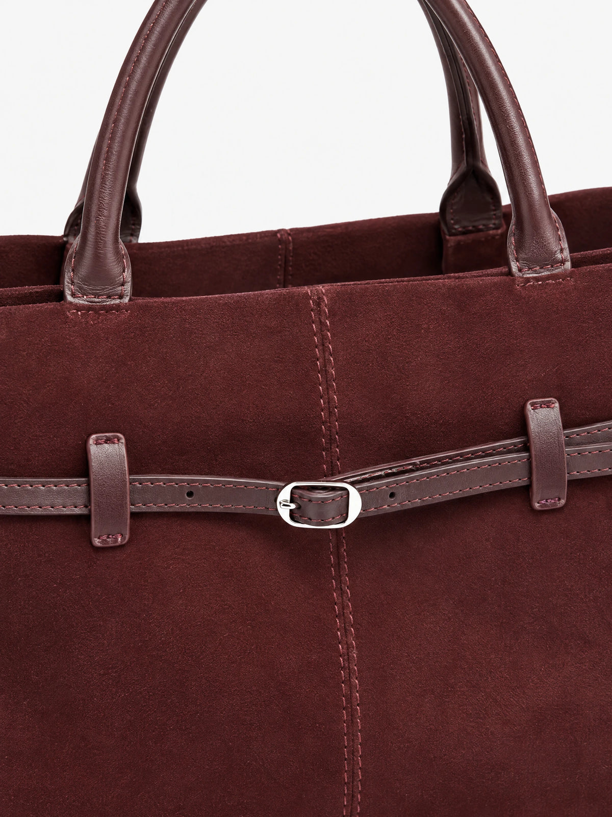 Close-up of the Wine Suede Leather Tote Bag showing stitched handles, suede texture, and an adjustable front buckle strap.