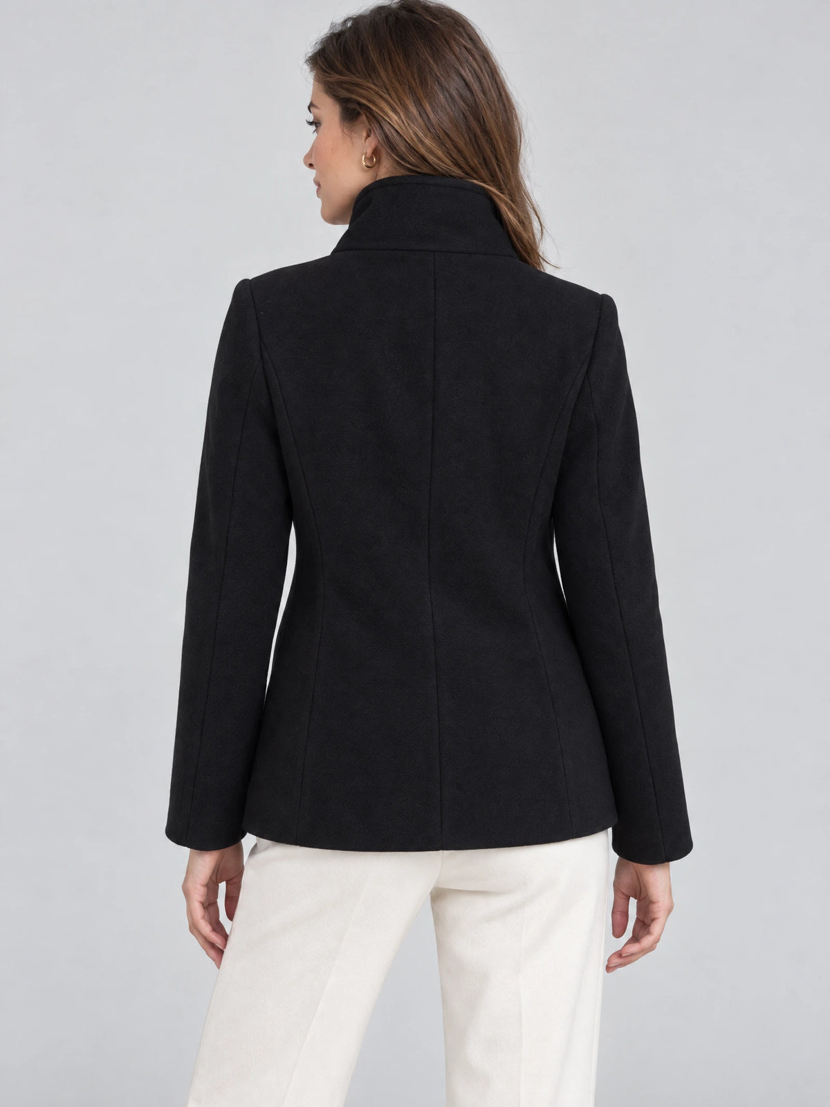Back view of a model wearing a Black womens turtleneck coat with a high collar and contoured back seams.