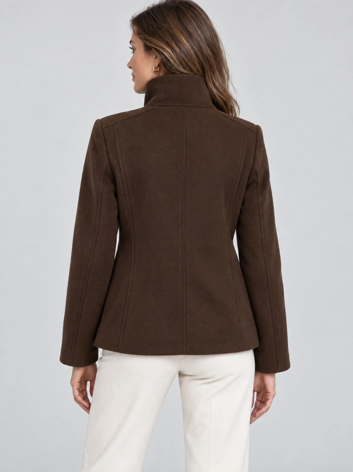 Rear view of a model wearing a Brown womens turtleneck coat with a high collar and tailored back seams.
