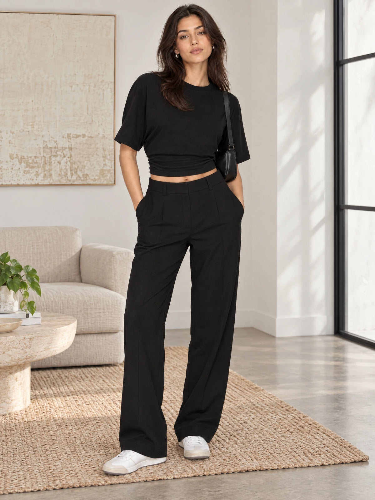 Model wearing a Black cotton Waist Short Top with an O-neck and short sleeves in a modern living room.