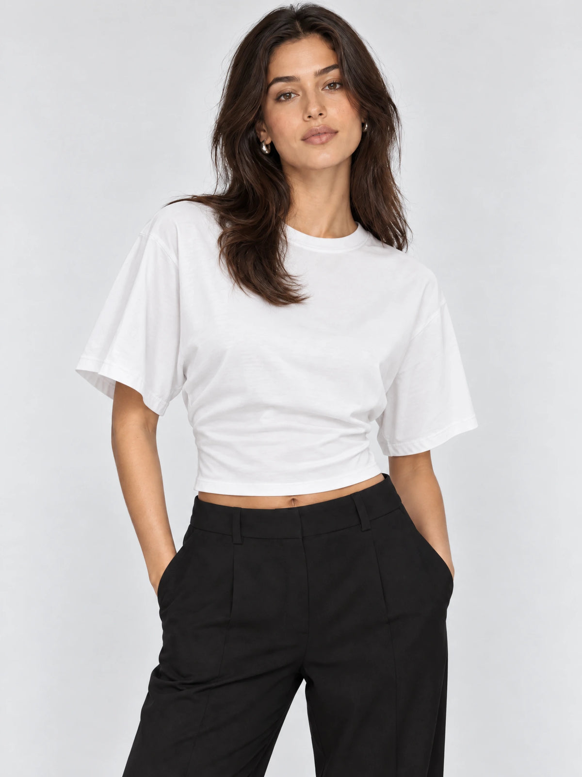 Model wearing a White cotton Waist Short Top with an O-neck and relaxed short sleeves in a front studio view.