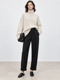 Model wearing a Beige turtleneck sweater with relaxed sleeves and ribbed trim in a front studio view.