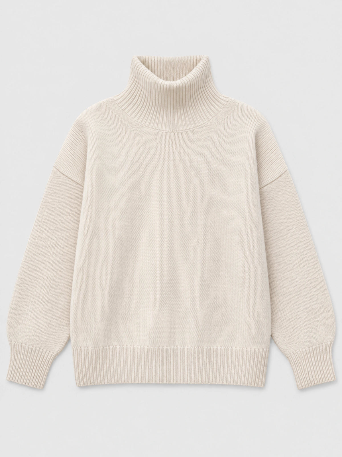 Beige women’s turtleneck sweater laid flat, featuring a ribbed high neck, dropped shoulders, and ribbed cuffs and hem.