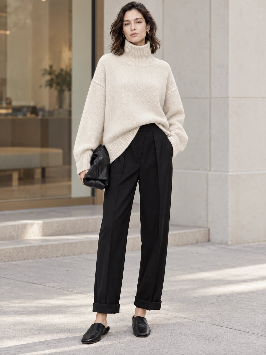 Model wearing a Beige turtleneck sweater with ribbed cuffs and hem outside a modern building.