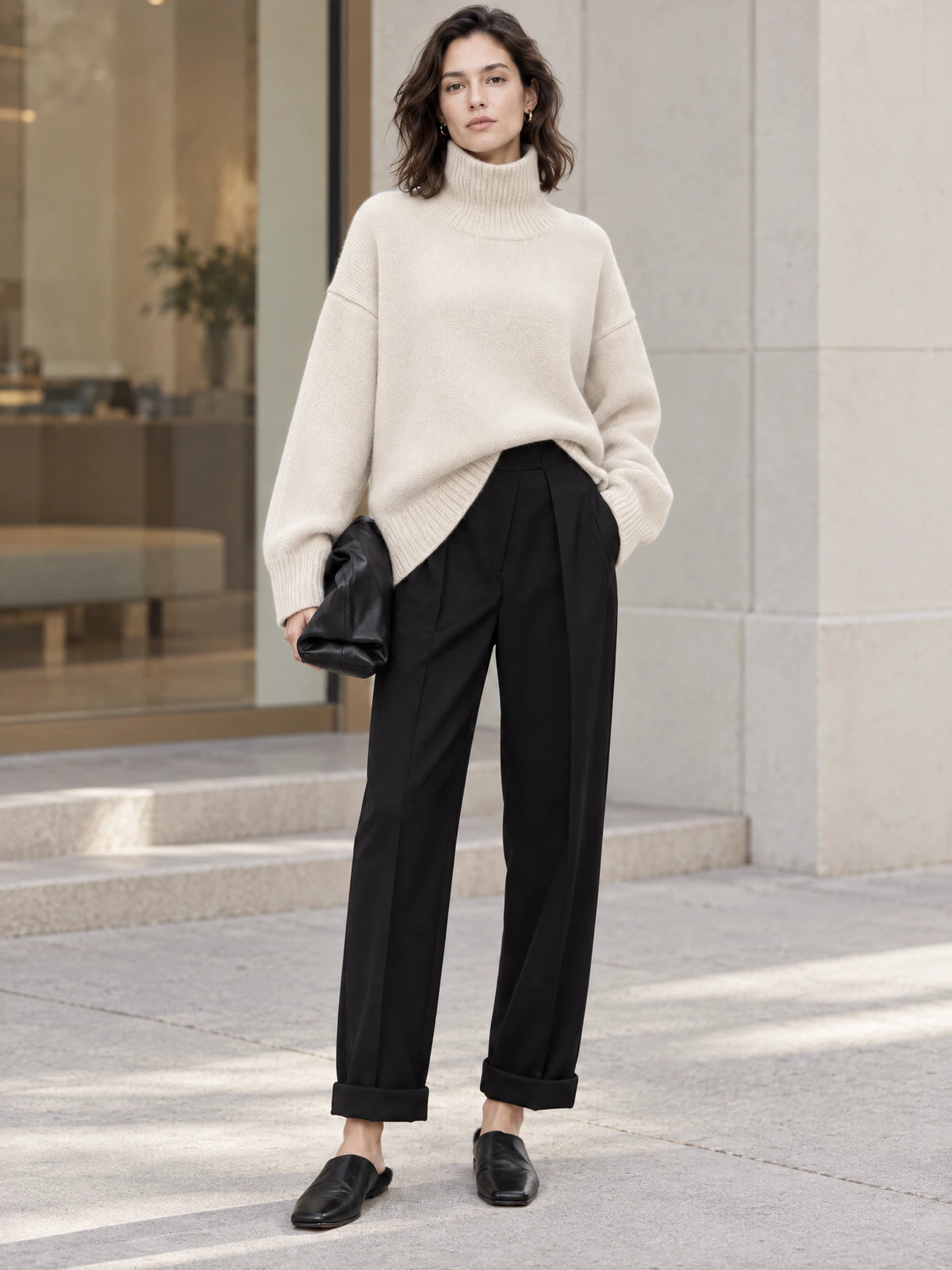 Model wearing a Beige turtleneck sweater with ribbed cuffs and hem outside a modern building.