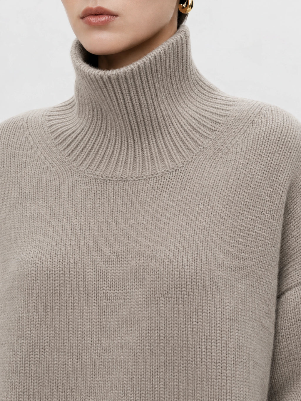 Close-up of the Khaki women's turtleneck sweater showing its ribbed high collar and textured knit.