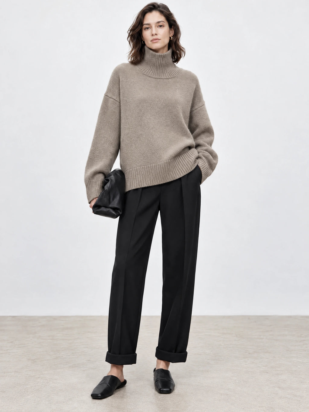 Front studio view of a model wearing a Khaki women's turtleneck sweater with ribbed collar, cuffs, and hem.