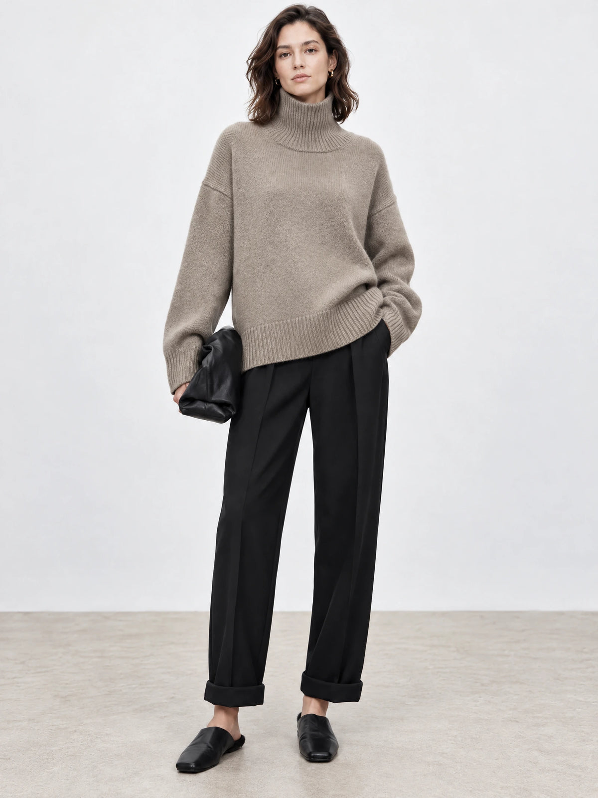 Front studio view of a model wearing a Khaki women's turtleneck sweater with ribbed collar, cuffs, and hem.