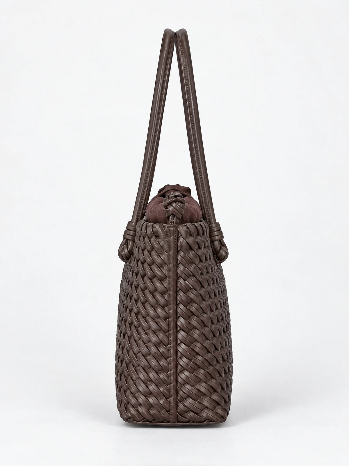 Side view of a Brown woven shoulder bag with braided texture, knotted top detail, and long double handles.